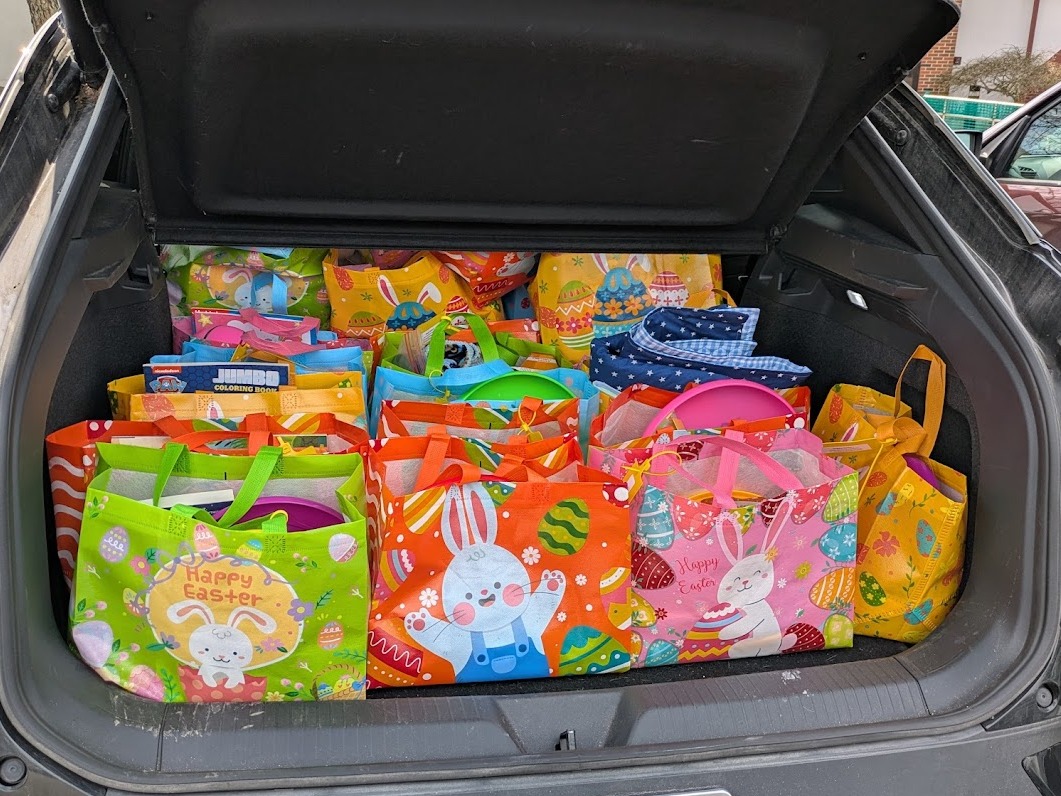 A car trunk full of colorful bags full of toys
